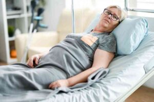 Jak wybrać materac przeciwodleżynowy? kobieta w podeszłym-wieku na łóżku